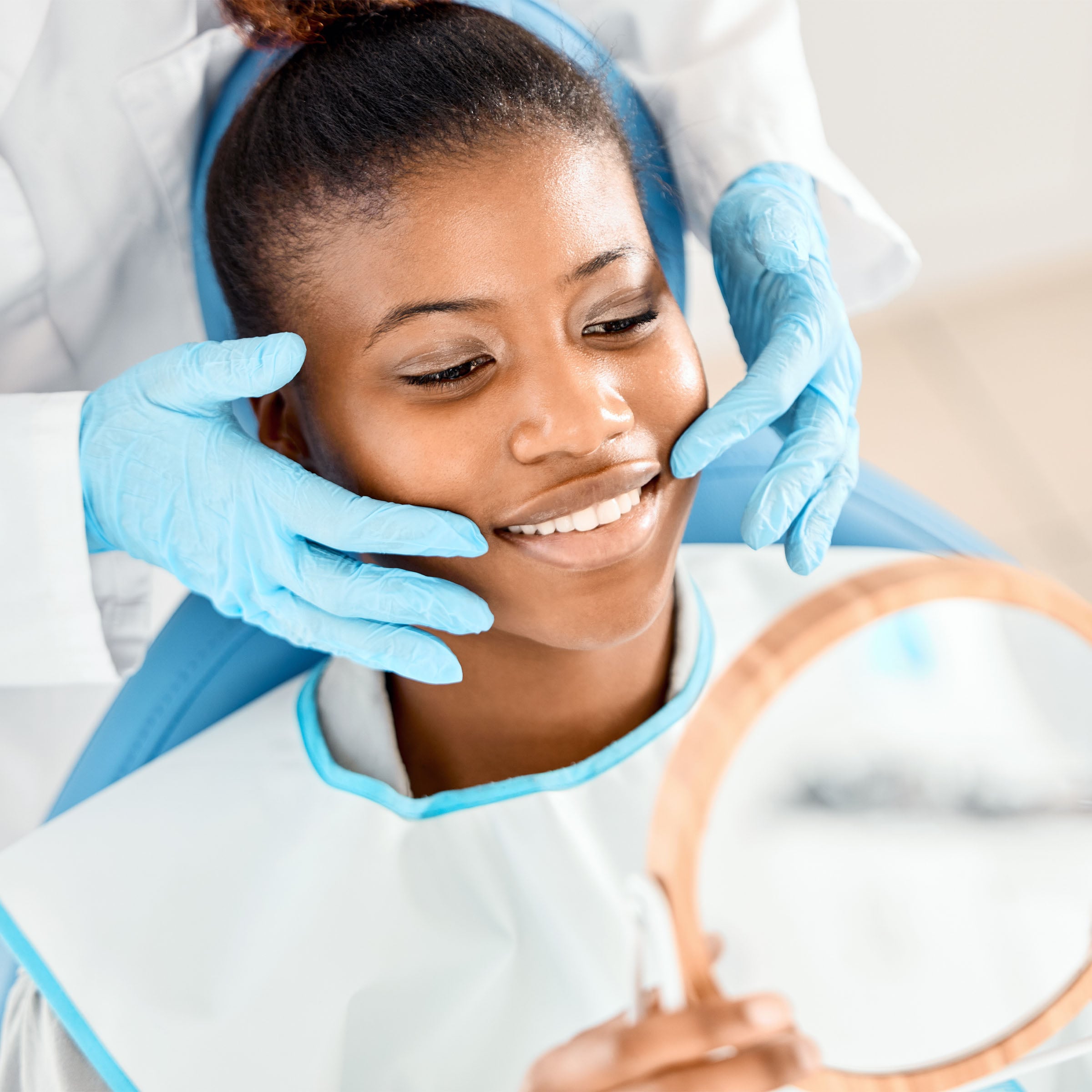 Woman in dental chair looking at beautiful smile